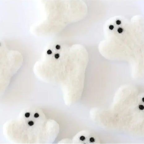 White marshmallow ghosts with black eyes on a white background